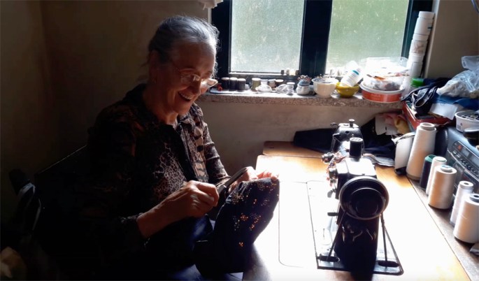 Dona Celeste a trabalhar na máquina de costura