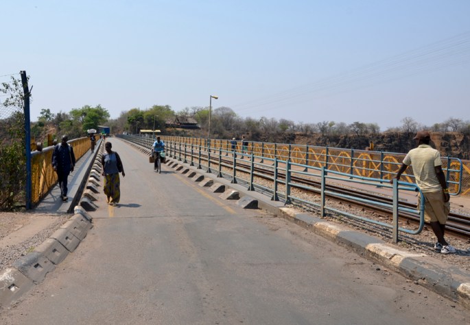 Pessoas a atravessar a fronteira e outros à espera de turistas