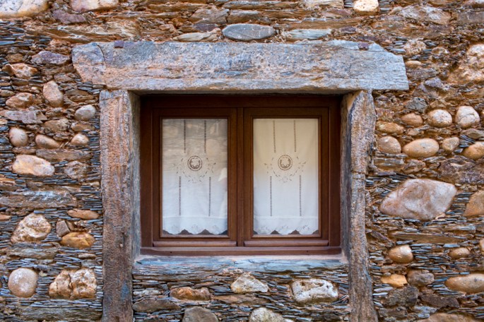 Janela de uma das casas de xisto e seixos