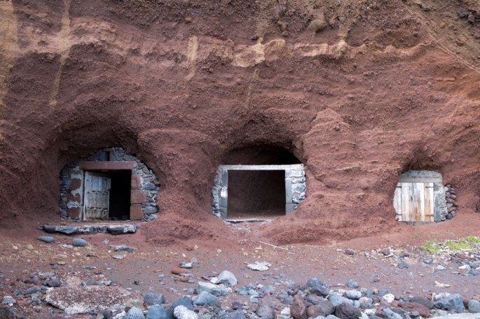 Arrumações de pesca e de barcos nos buracos na falésia