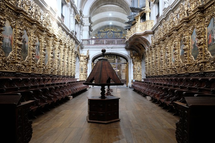 Cadeiral e decoração do coro-alto. Ao fundo a grade que separa da igreja